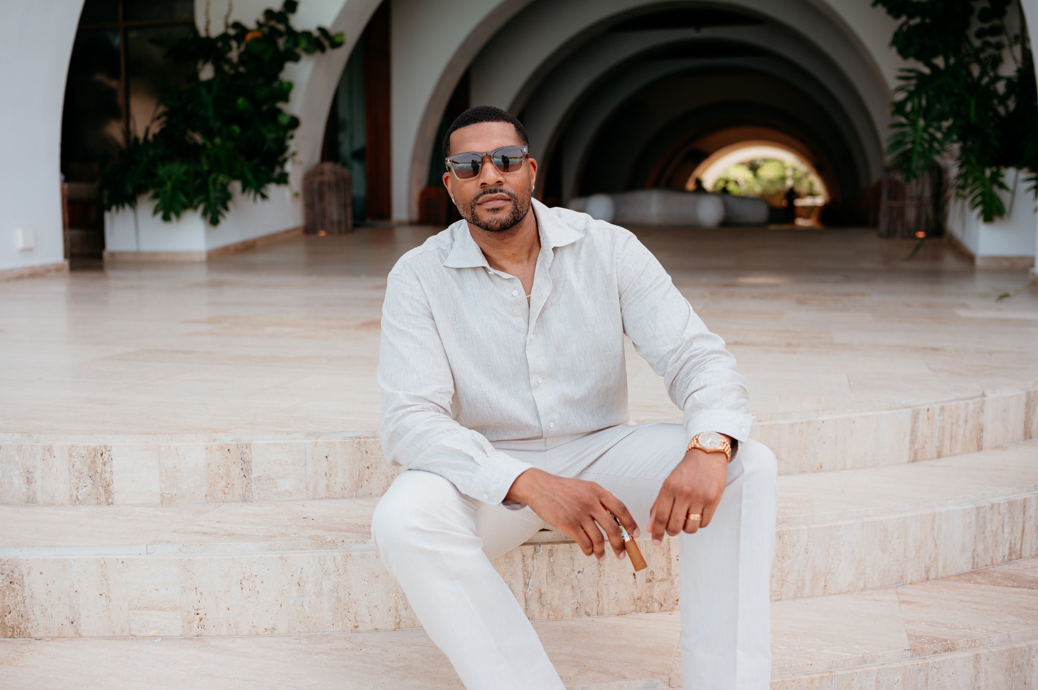 Corey Williams seated in a warm luxury travel setting
